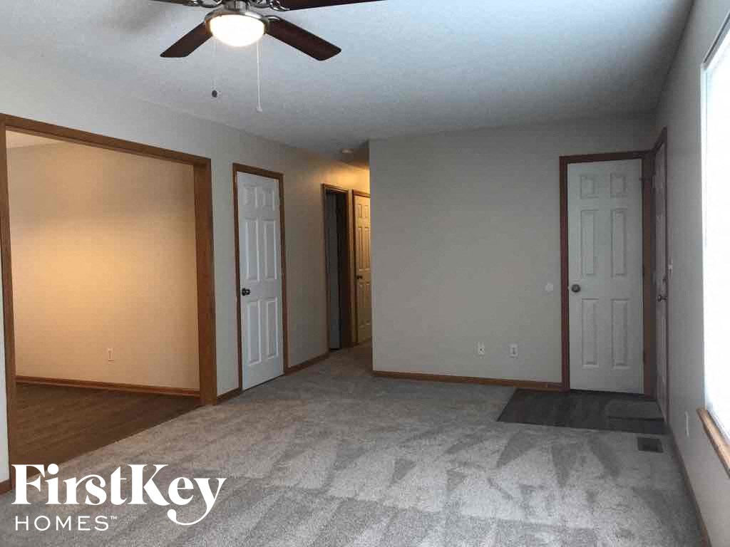 A room with a ceiling fan and a carpeted floor.
