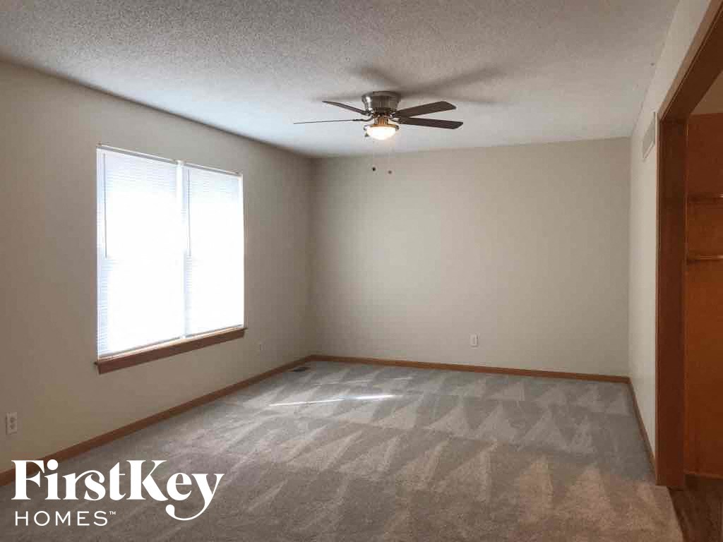 A room with a ceiling fan and a window.