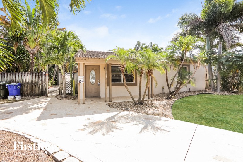 a small house with palm trees in front of it