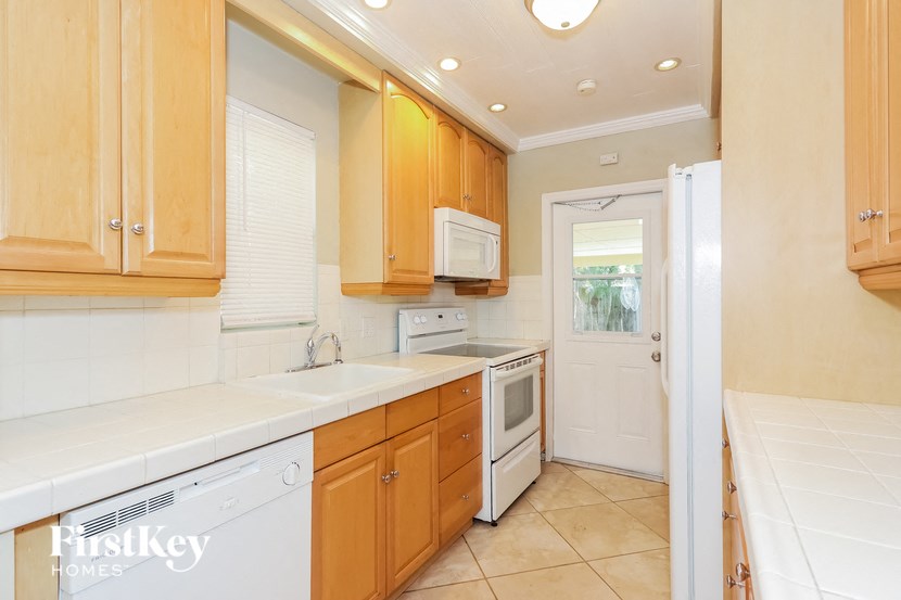 a kitchen with white appliances and wooden cabinets