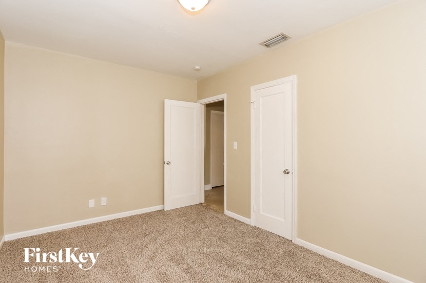 a bedroom with two doors and a carpeted floor