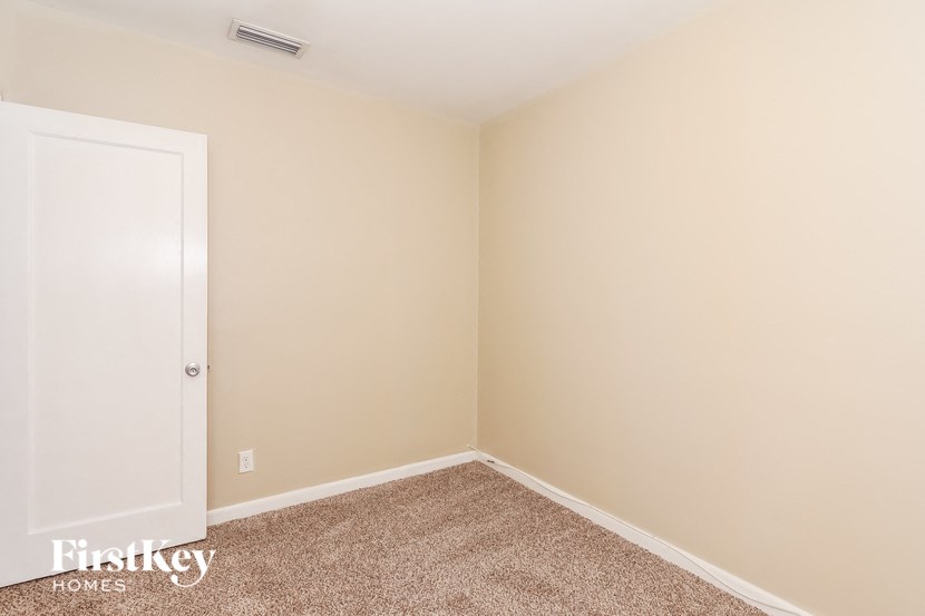 a empty room with a white door and a carpet