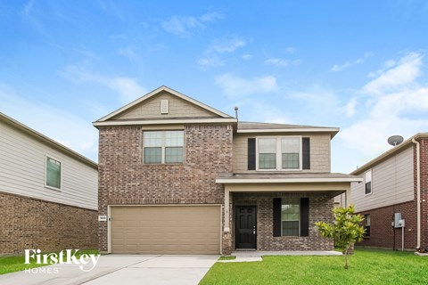 A house with a garage and a driveway in front.