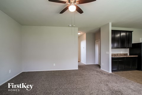 A room with a ceiling fan and a carpeted floor.