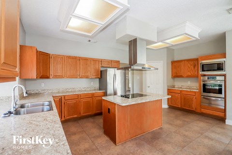 A kitchen with wooden cabinets and a marble countertop.