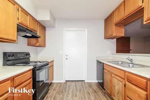 a kitchen with wood flooring and wooden cabinets