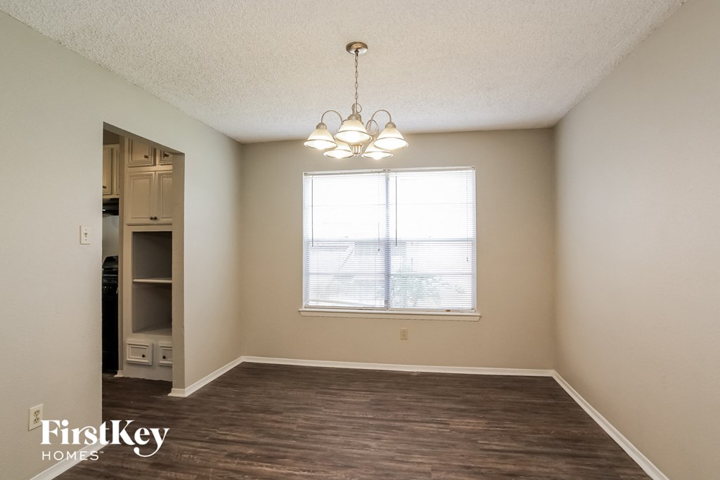 an empty living room with a large window and a closet