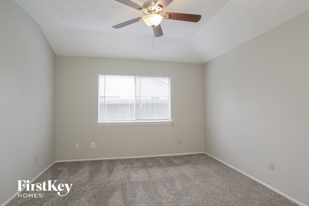 a bedroom with a ceiling fan and a window