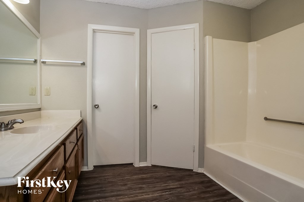 a bathroom with a bath tub and a sink and a mirror