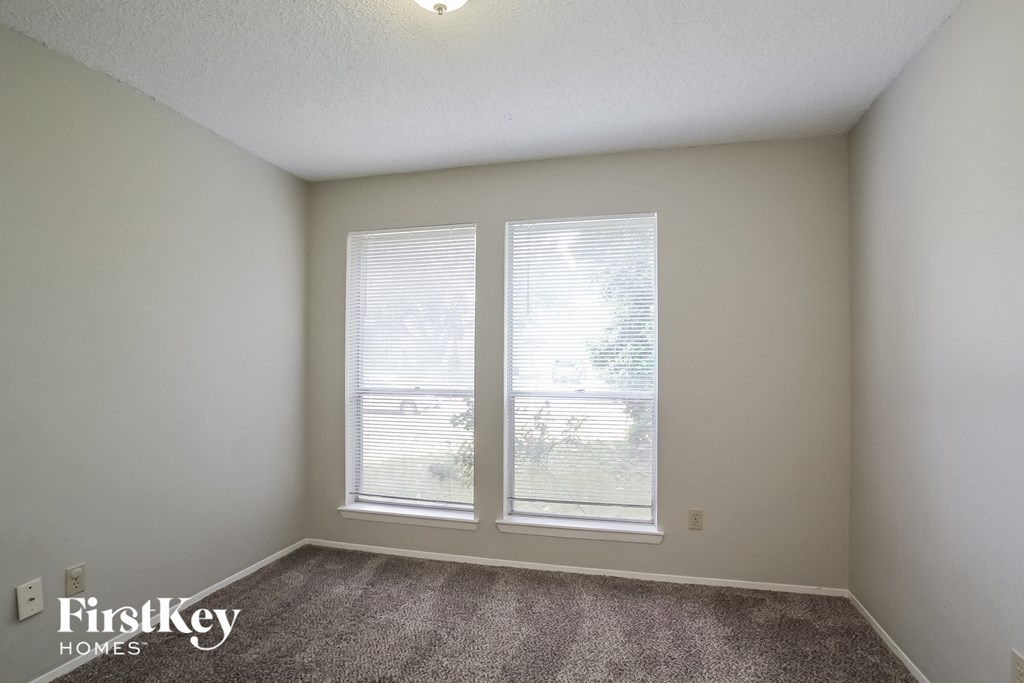 the living room of an apartment with two windows