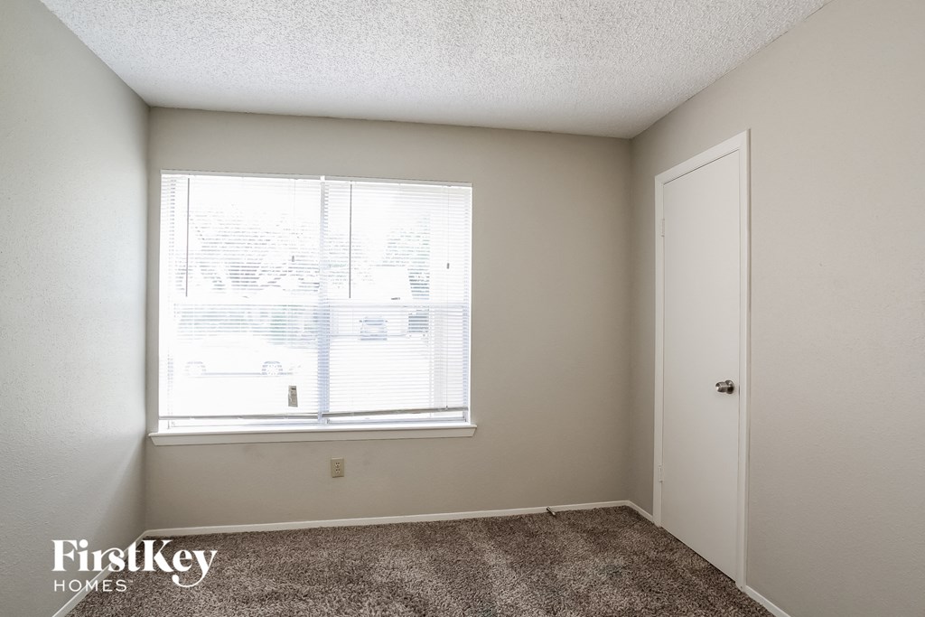 the living room of an apartment with a window and a door
