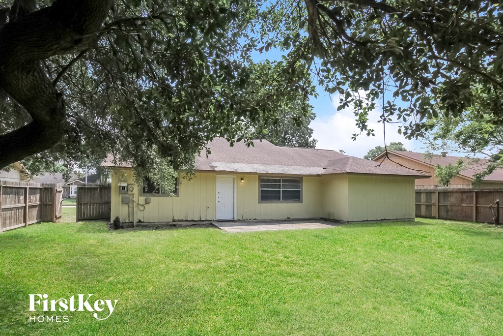 a small yellow house with a yard and a tree