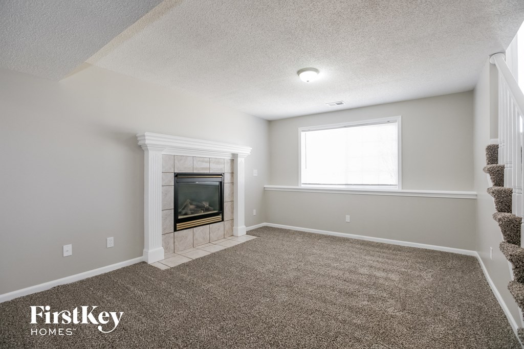 the living room has a fireplace and carpeted flooring