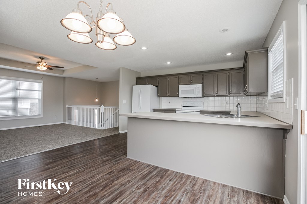 an open kitchen and living room with a white counter top