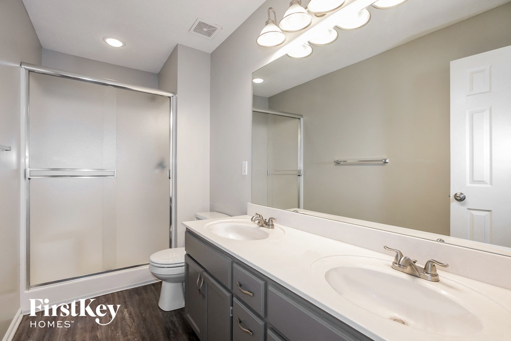 a bathroom with two sinks and a shower and a toilet