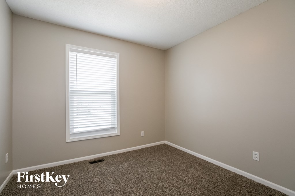 a empty room with carpet and a window