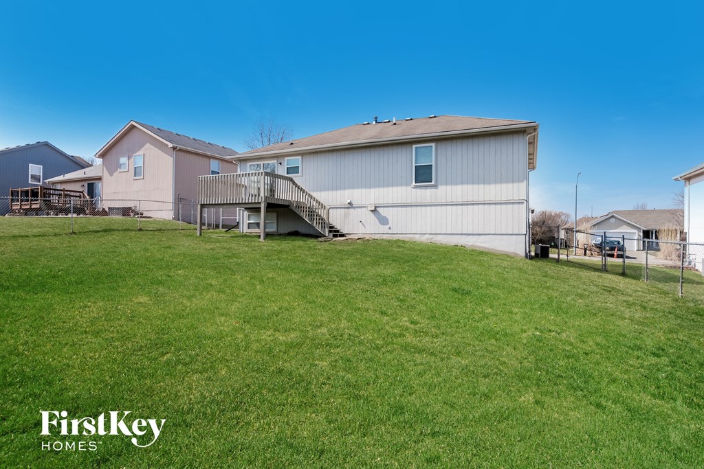 the backyard of a house with a yard and a deck