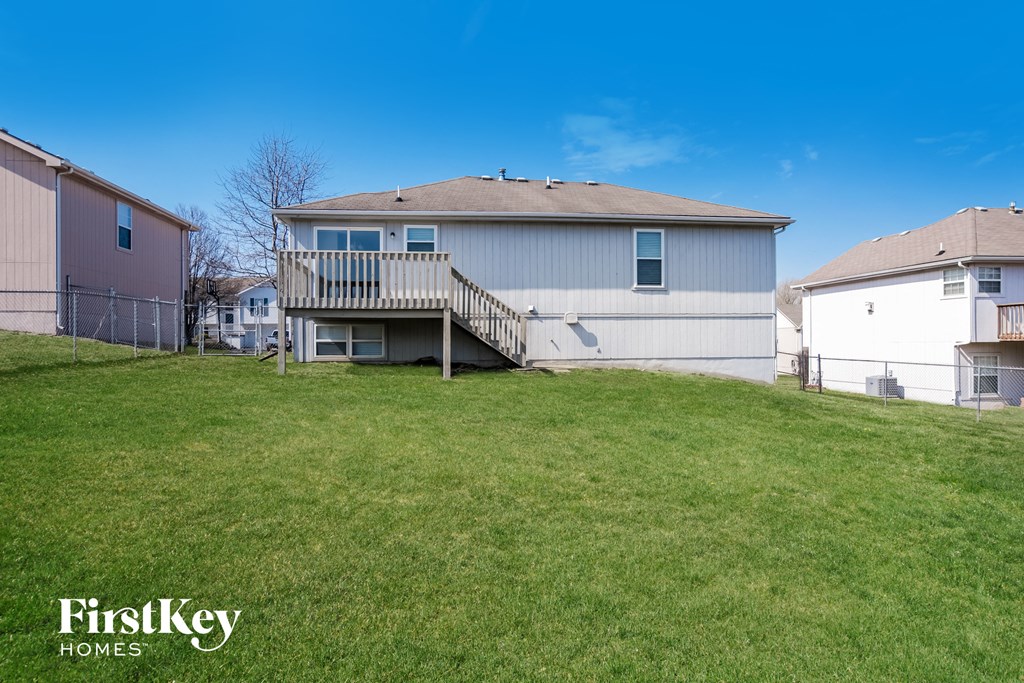 the backyard of a house with a deck and a yard