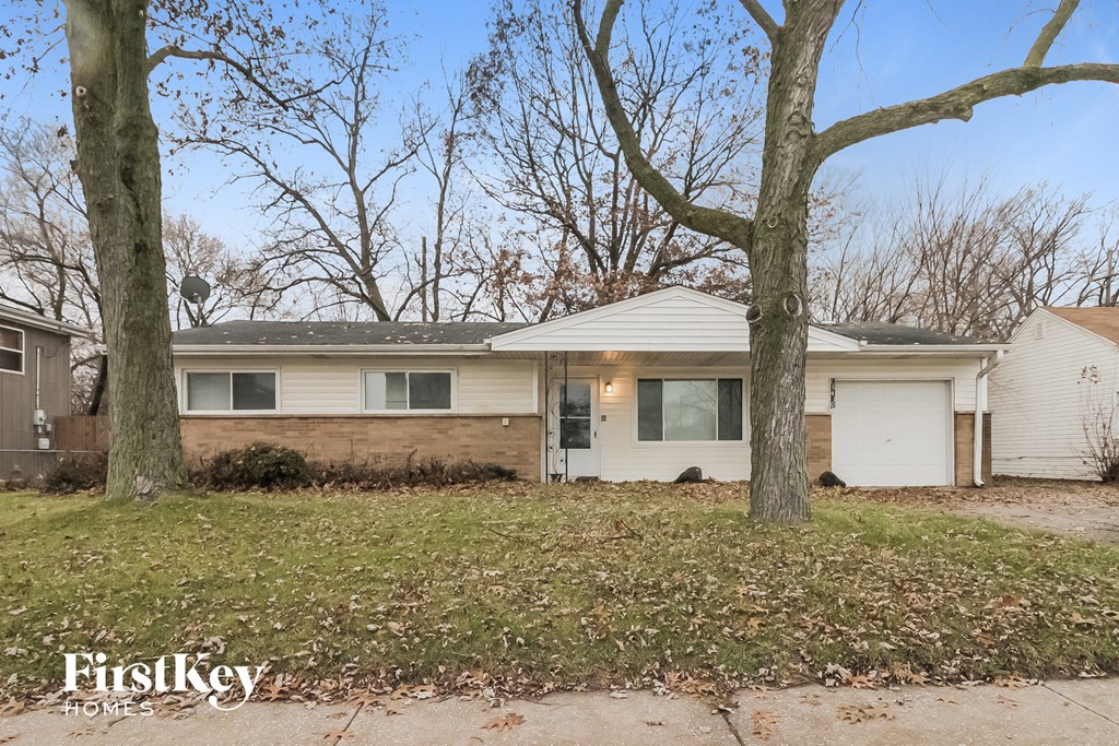 a white house with two trees in front of it