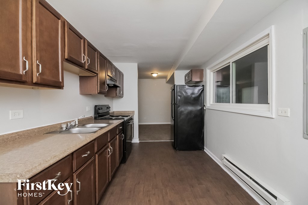 a kitchen with wooden cabinets and stainless steel appliances and a window