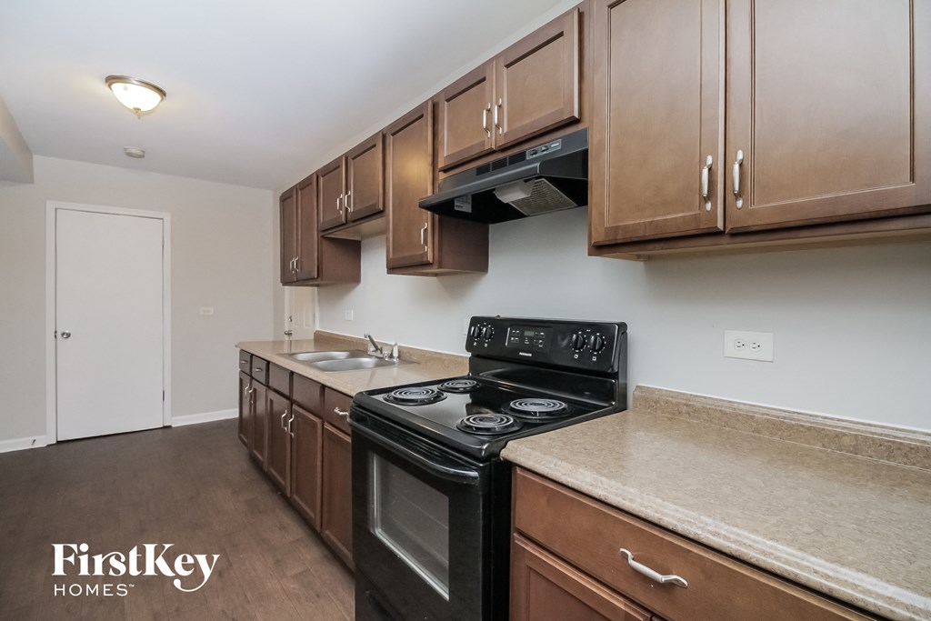 a kitchen with wood cabinets and black appliances and a stove top oven