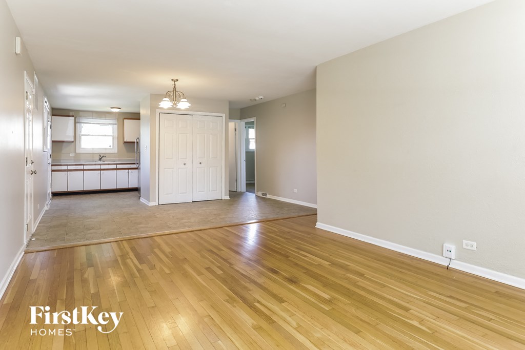 the living room and dining room of an empty house with wood flooring