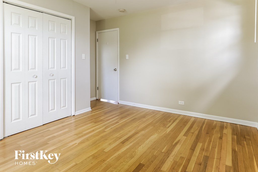 the living room of a house with wood floors and white walls