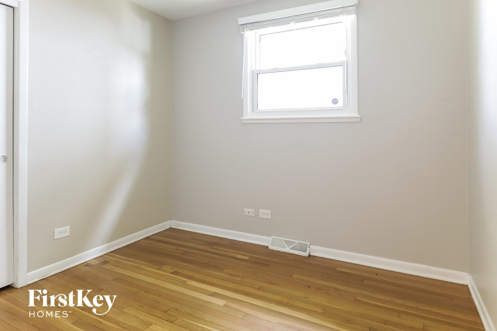 a small room with wooden floors and a window