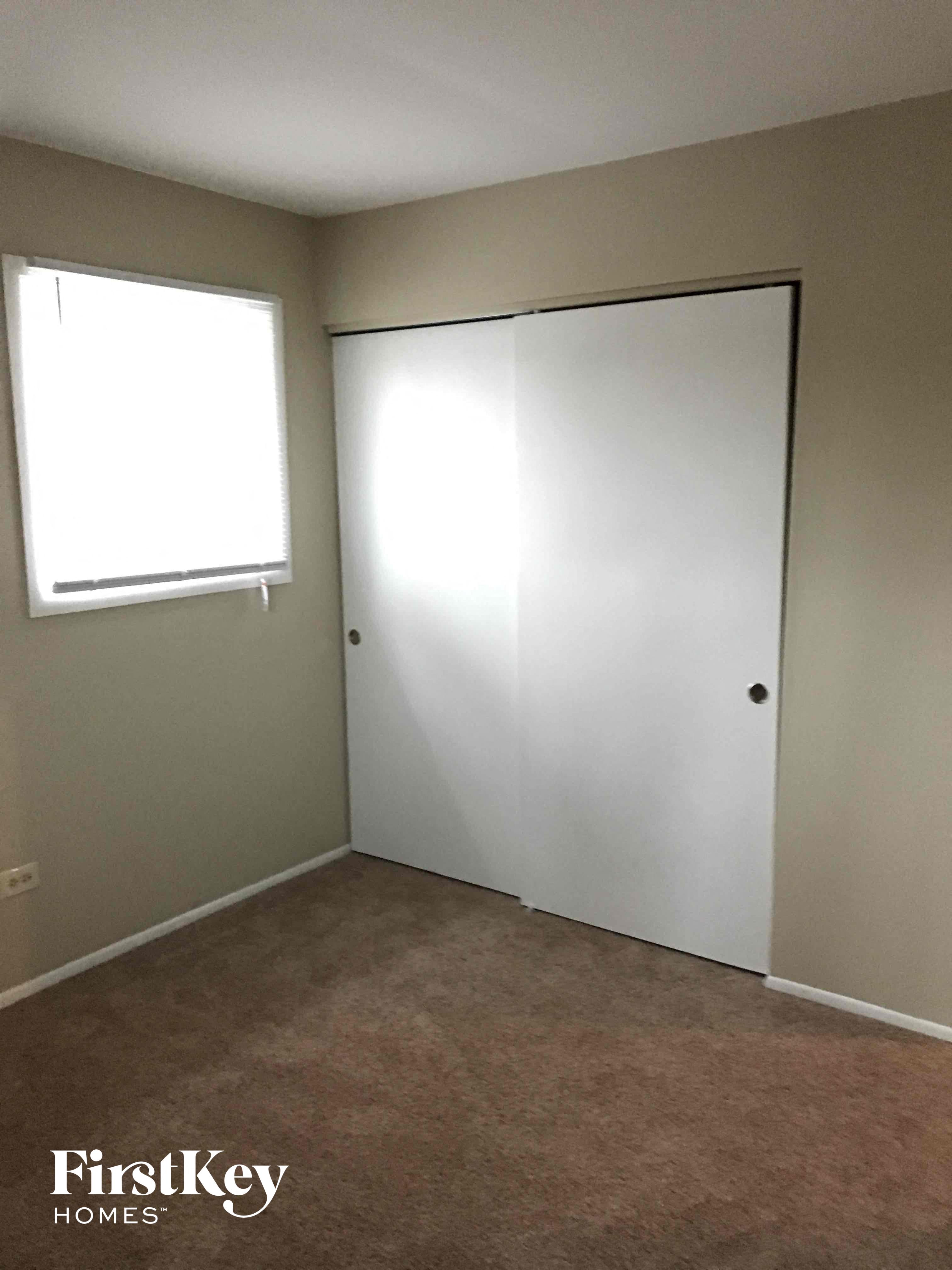 a room with a closet and a window and a door
