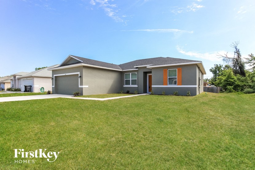 A house with a grey roof and orange trim is for sale.