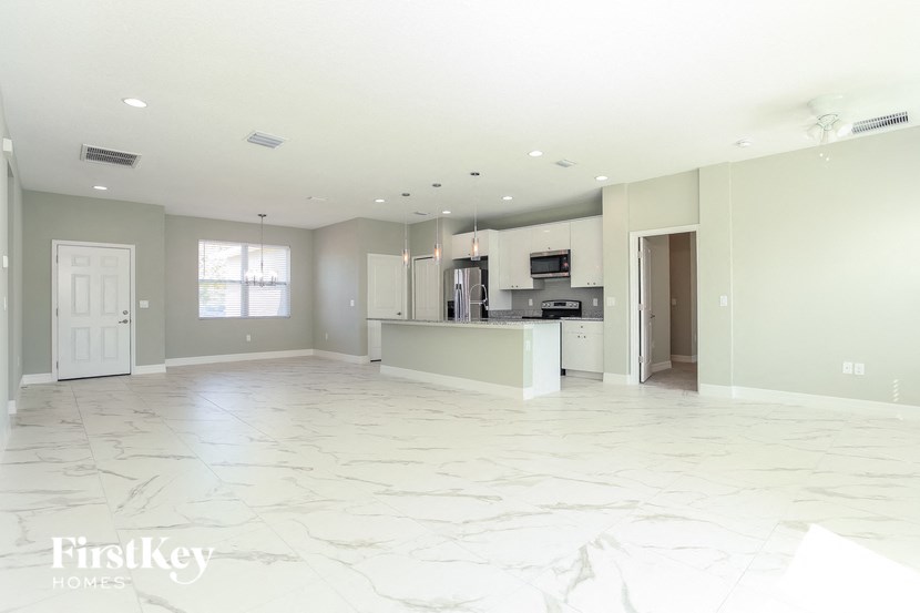 A spacious kitchen with a marble floor and white walls.
