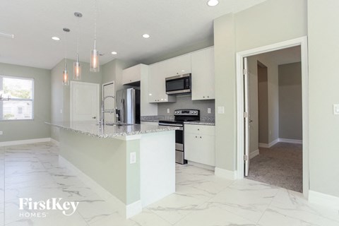 A kitchen with a marble floor and a white counter top.