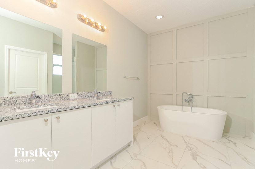 A bathroom with a marble floor and a bathtub.