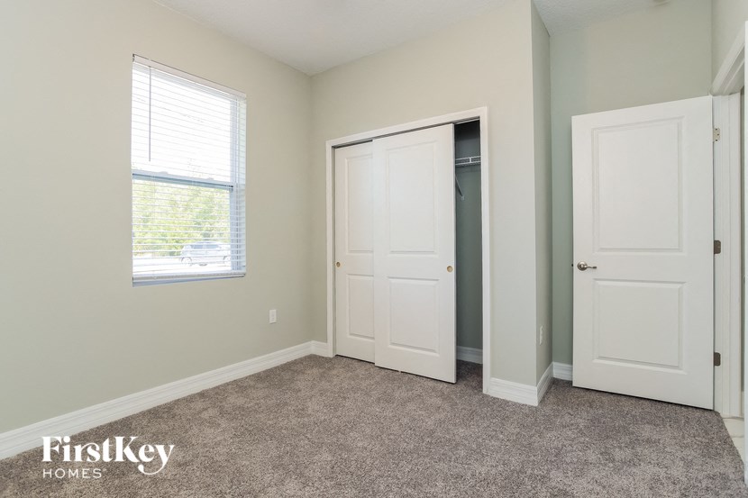 A room with a carpeted floor and two white doors.