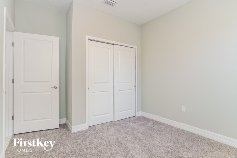 A room with two white doors and a carpeted floor.