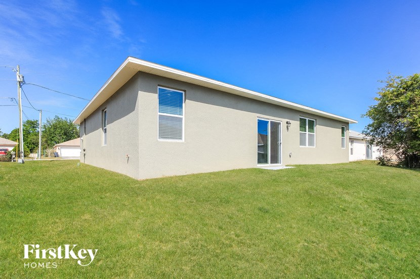 A small house with a grey roof and a blue sky in the background.