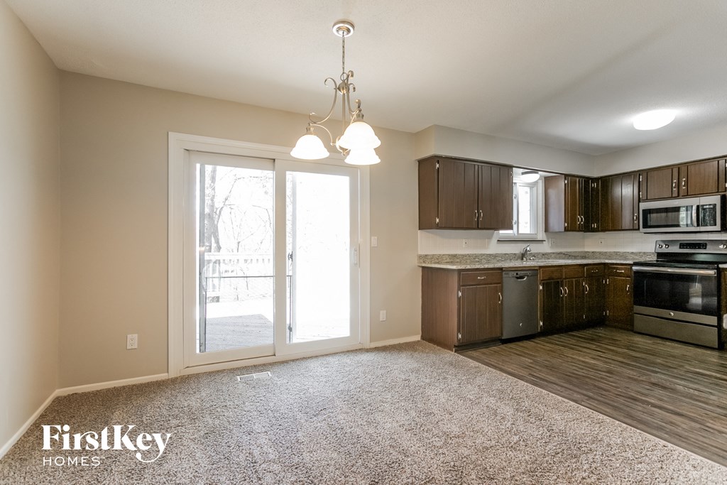 an empty kitchen and living room with a door to the patio