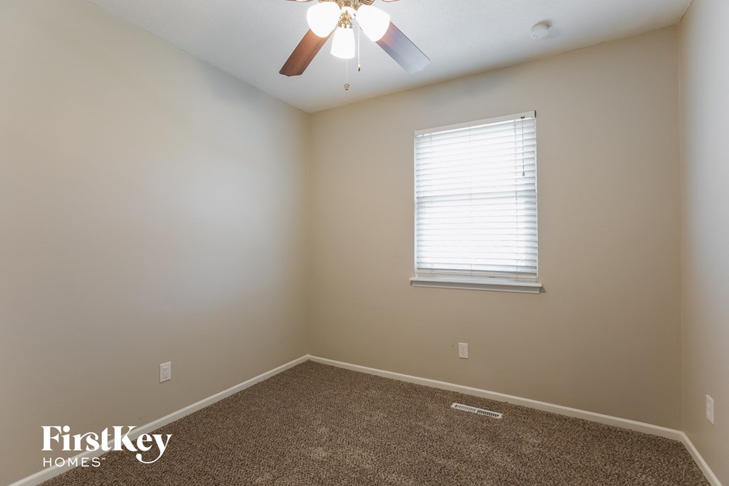 a bedroom with a ceiling fan and a window