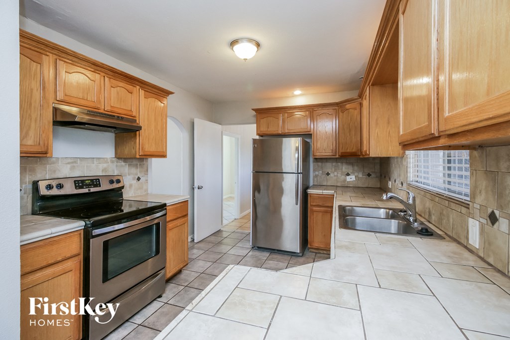 a kitchen with wooden cabinets and stainless steel appliances