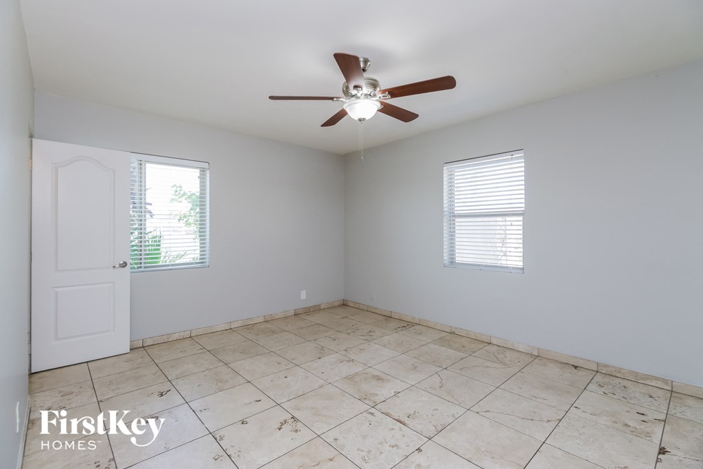 a room with a ceiling fan and a tiled floor
