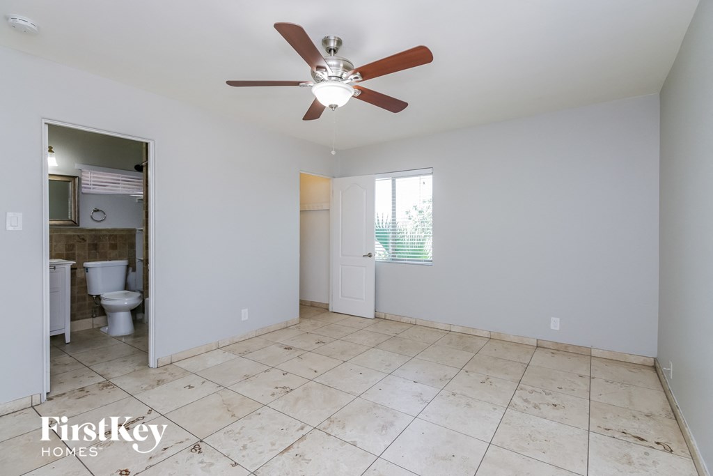 an empty room with a ceiling fan and a bathroom