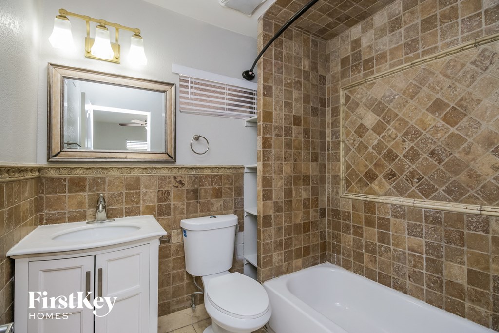 a bathroom with a sink toilet and tub and a mirror
