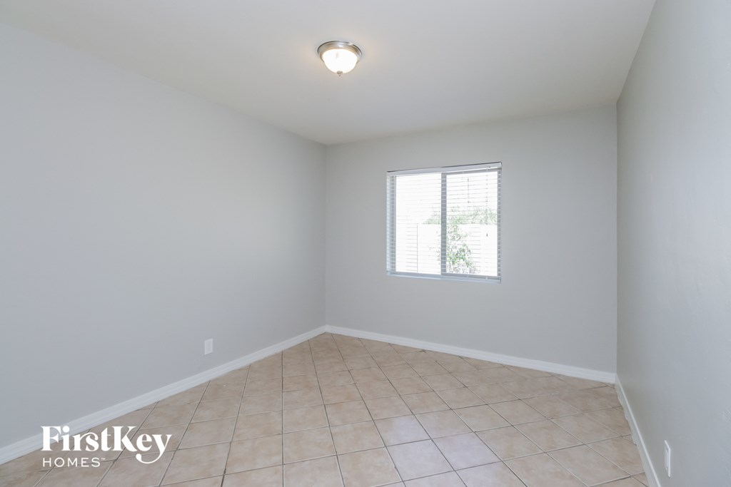 an empty room with a window and a tiled floor
