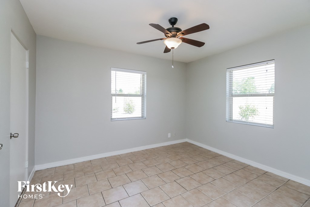a living room with a ceiling fan and a tiled floor