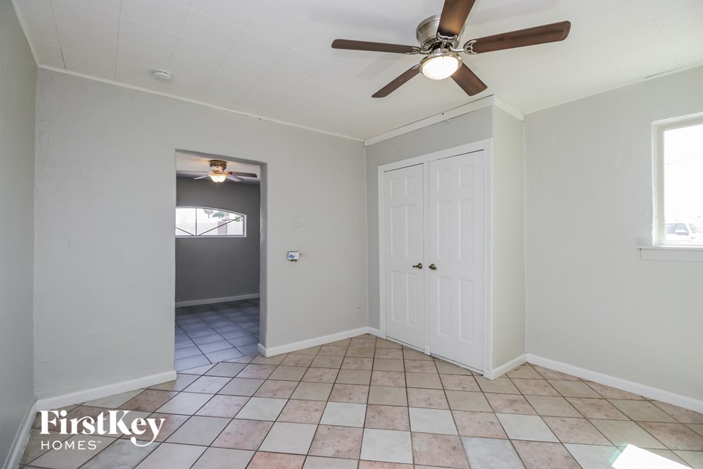an empty room with a ceiling fan and a door to a hallway