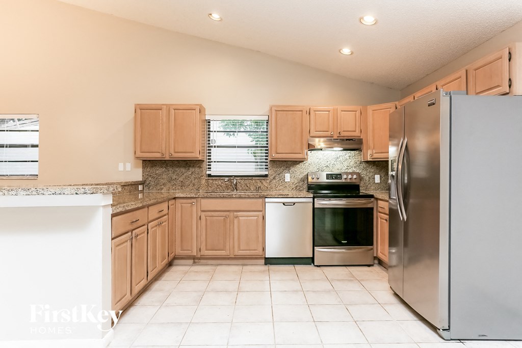a kitchen with wooden cabinets and stainless steel appliances