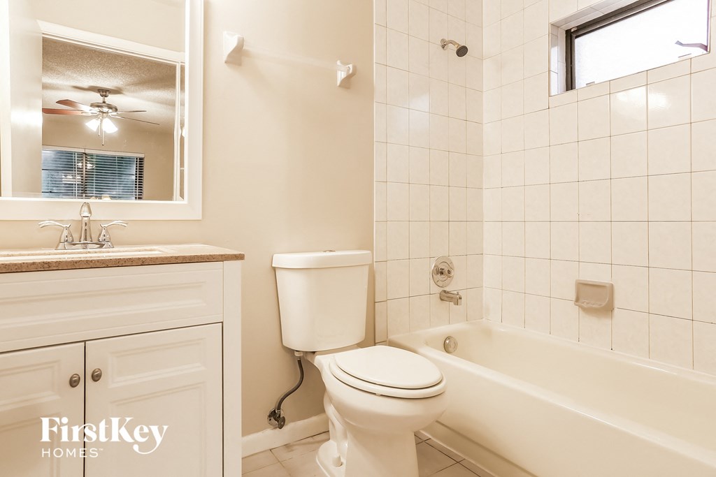 a bathroom with a toilet and a tub and a sink
