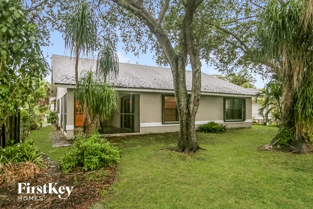 a white house with a yard and trees