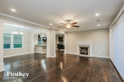 a living room with a fireplace and a ceiling fan