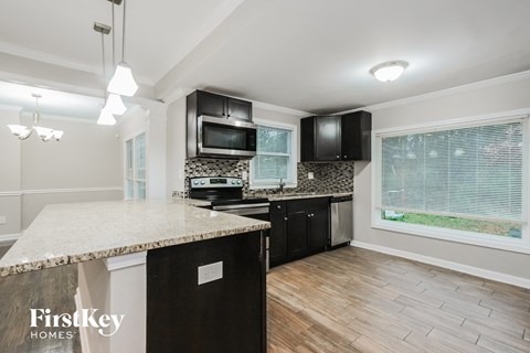 a kitchen with black appliances and a marble counter top
